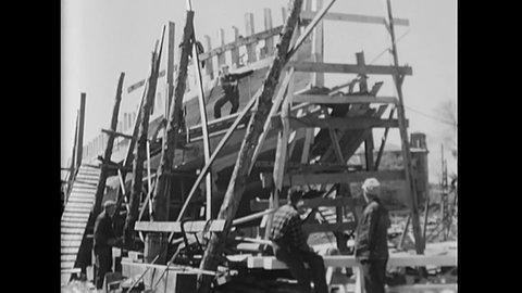 CIRCA 1947 - Work on a hand built wooden fishing boat is continued by men, interspersed with scenes of some of the men singing and dancing.
