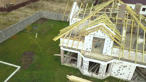 Aerial view of a private house with aerated concrete brick walls and wooden frame for future roof.