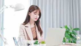 telework concept - Asian business woman use computer to join a video meeting at home