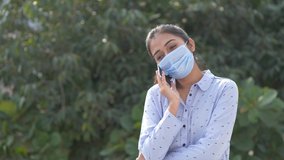 Lifestyle during covid-19, quarantine. Young woman in medical protective mask making selfie during walking in summer park, video chat conference with friends, after covid
