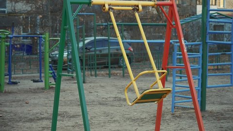 lonely swing swinging in the wind without people in the coronavirus. pandemic stay home pandemic. children playground no people covid 19 swing . children swing during the coronavirus period