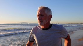 64 year old man getting his exercise at the beach at sunset. Slow Motion. - Powered by Shutterstock - Get 15% off with code: PIKWIZARD15