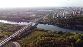 view of the forest, road, road bridge over the river and urban residential high-rise buildings, shooting video from a bird's eye view.