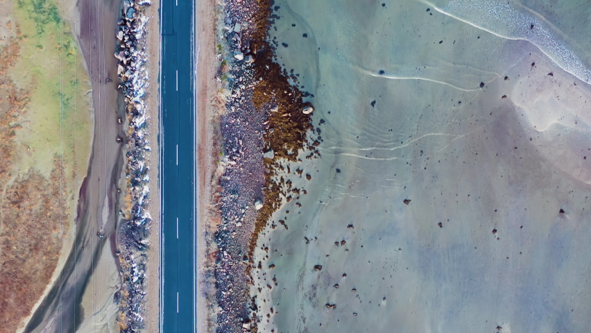 Empty asphalt road along the coast. Perpendicular aerial drone cinematic shot