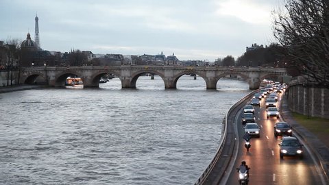 River Seine, bridge on left see Eiffel Tower, right move cars by road Voie Georges Pompidou at Paris in evening