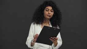positive bi-racial call center operator showing contract isolated on black