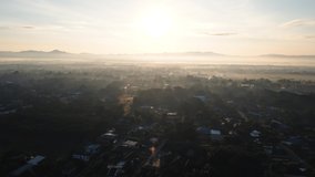 Establishing Aerial View Shot of sunrise with fog above asia village.