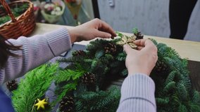 Woman decorates a Christmas wreath with a golden star made of twigs. Close-up. Making Christmas decorations. - Powered by Shutterstock - Get 15% off with code: PIKWIZARD15