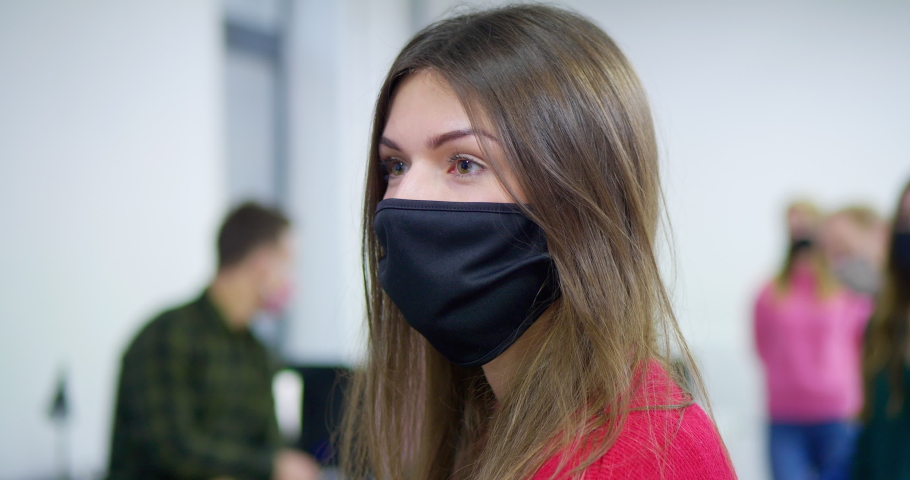 MS DS Young woman removing protective face mask