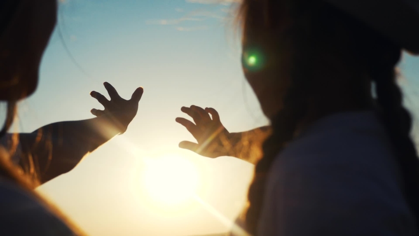 hands in the sun. mom and daughter hands reach out to the sun silhouette sunlight. happy family kid dream concept sunset. mom and daughter dream of god religion concept