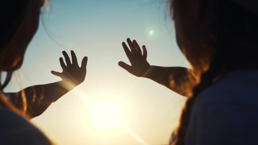 Hands in the sun. mom and daughter hands reach out to the sun silhouette sunlight. happy family kid dream concept sunset. mom and daughter dream of god religion concept | Shutterstock HD Video #1064484589