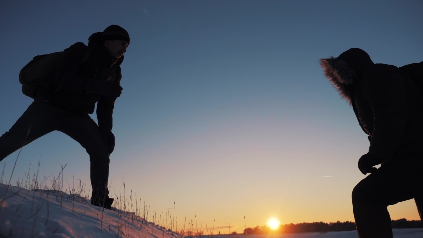 teamwork. helping hand a business travel silhouette concept. group team winter lends helping hand climb cliffs mountains helping hand. teamwork people snow climbers climb top overcoming hardships