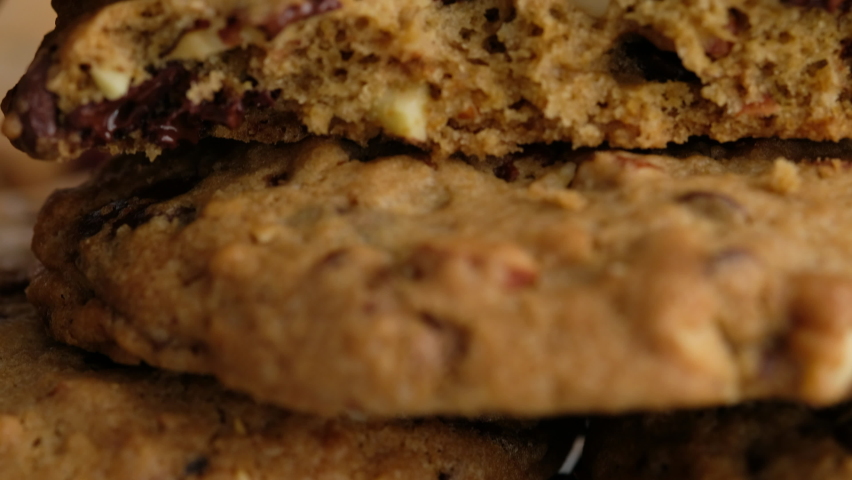 Camera movement. Close-up of a chocolate chip cookie lies on the wire rack. A woman makes a chocolate chip cookie in 4K. The concept of making chocolate chip cookies step by step. Royalty-Free Stock Footage #1064488540