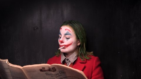 New York, USA - 12 October 2019: Joker Cosplay Actor Smoking and burn the New York Times Newspaper, Halloween Concept