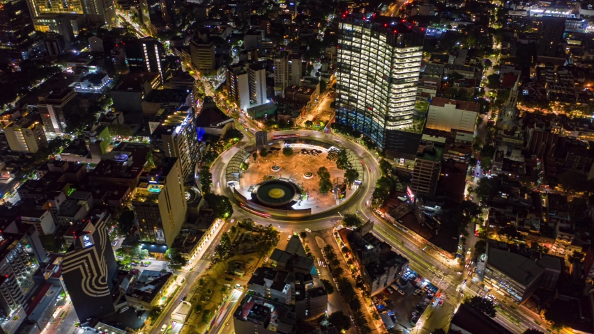 Mexico City Insurgentes roundabout at night with traffic and public transportation, drone shot hyperlapse