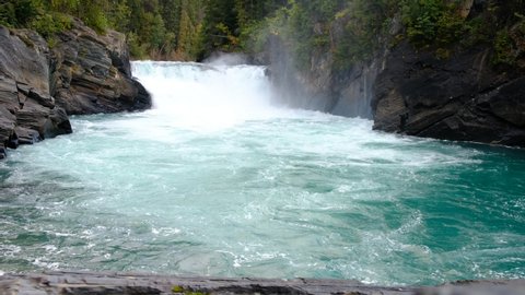 A wide angle of a large waterfall basin where water running rapidly, a 4K video clip at "Overlander Falls", British Columbia, Canada.