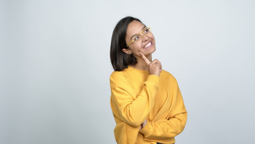 Young latin woman with glasses standing and thinking over isolated background