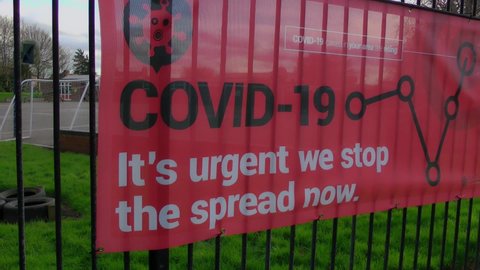 Primary school in England closed tier 4 , coronavirus spreading. Empty playground filmed through iron railings. Covid-19 red street sign. England in Christmas lockdown. London, UK England. 21.12.2020 
