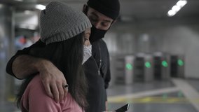 Closed shot of a young interracial couple walking hugging in a subway corridor and talking about something they're seeing on their smart phone. - Powered by Shutterstock - Get 15% off with code: PIKWIZARD15