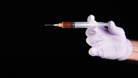 A conceptual video of a nurse dispensing narcotics through a syringe while poised against a black background.