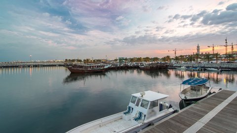 Fishing boat parked near the fish market next to Kuwait City Area day to night transition timelapse. Beautiful cloudy sky after sunset