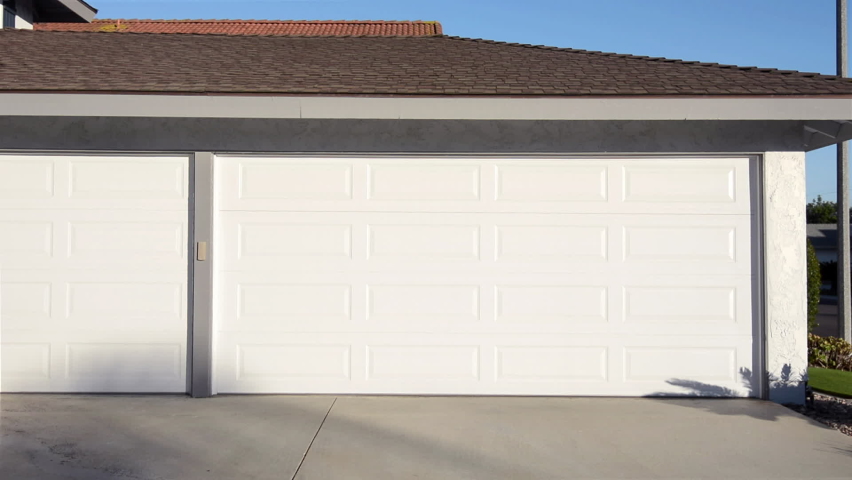 A residential home with an automatic roll up garage door moving in the opening position. Royalty-Free Stock Footage #1064536885