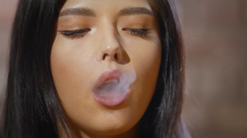 Young stylish woman smokes. Portrait girl close up.	
