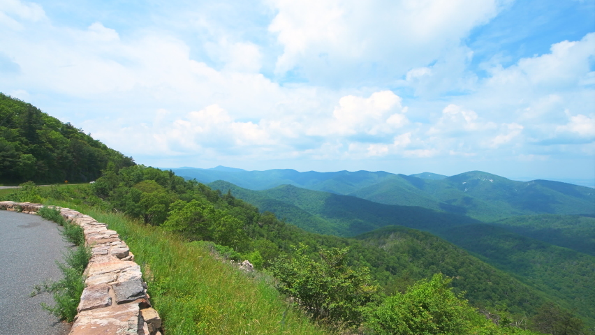 Panning overlook view of horizon in Appalachian Shenandoah Blue Ridge mountains on skyline drive park with rolling hills in summer