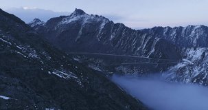 Drone flying along the ridge Winding road hovering on the mountainside with sea of clouds at twilight nature landscape aerial 4k footage