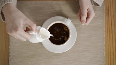 Pouring hot milk into a cup o espresso,