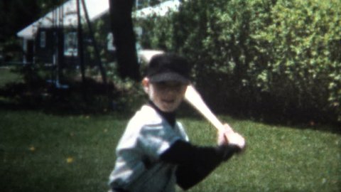 KANSAS CITY, USA - MAY 1966: Boy practice swinging like baseball legend 'Babe Ruth' by pointing to where the ball is going to go with the bat.