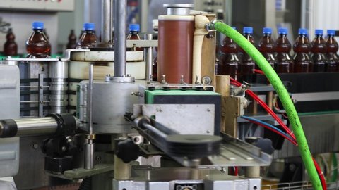 BELORECHENSK, RUSSIA - OCTOBER 09, 2020: The machine sticks labels on plastic bottles of fresh beer moving on a conveyor belt at the brewing plant in Belorechensk, Republic Of Adygea, Russia
