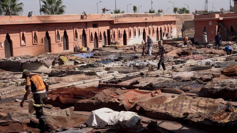 Morocco, Marrakech - October 2019: Workers collect animal hides drying in the sun at an ancient traditional Leather Tannery