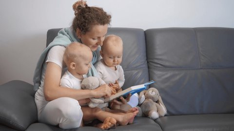 Happy Mother Reading Book To Her Twin Babies.