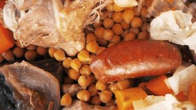 A close up video of a dish of a delicious and healthy homemade Cocido madrileño, also known as Madrilenian stew, which has chickpeas and meat based on a traditional recipe and cooked in Madrid, Spain.