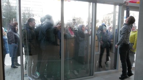 Doors open, people buyer run in store. People breaking doors, running past security guard during Black Friday sale in clothing store: Gomel, Feb 2020