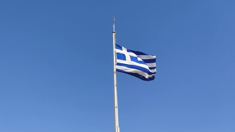 Greek Flag Waving Proudly Under the Bright Blue Sky on Parthenon Temple in Athens City, Greece, 4K Video Footage