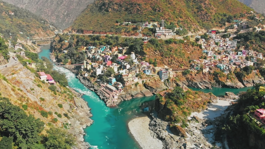 Devprayag is a town in Tehri Garhwal district in the state of Uttarakhand, India, and where Alaknanda, Saraswati River, and Bhagirath rivers meet and take the name Ganga. Aerial View 4k. Royalty-Free Stock Footage #1064596639