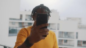 Video call. African american black man with dreadlocks having video call using smartphone. High quality 4k footage