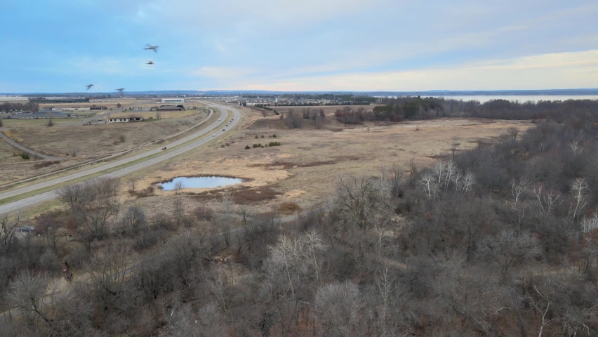 A road going by the fields near a small lake in Chippewa Falls, Wisconsin, USA