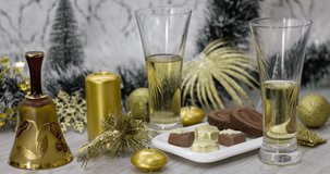 An alcoholic drink on the New Year's table, beautiful golden decorations and toys.