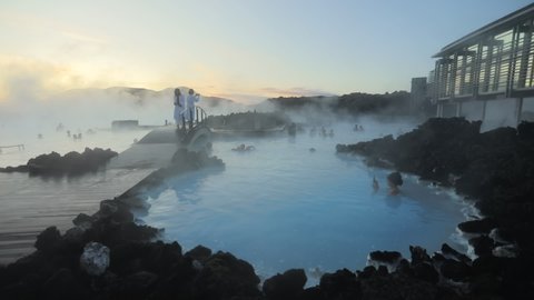 Blue Lagoon, Iceland. Misty hot spring with tourists during sunny day. Geothermal spa in lava field. High quality FullHD footage