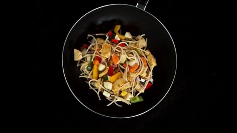 Super slow motion of flying asian chicken noodles with vegetable from pan. Filmed on high speed cinema camera, 1000 fps.