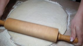 a woman rolls out the dough with a rolling pin for making homemade cakes, home video on the phone