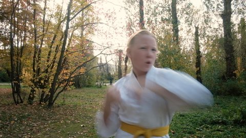 teenager girl 12 years old is engaged in karate outdoors in the park. Healthy lifestyle concept. playing sports. martial arts. Judo, Jiujitsu. brave, strong. works out elbow strikes. workouts