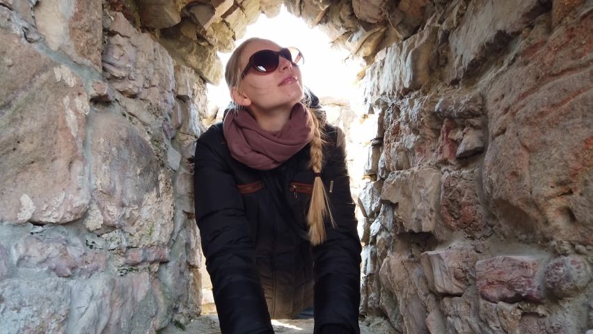 Medium shot Girl inspecting the walls of an old castle in Europe.