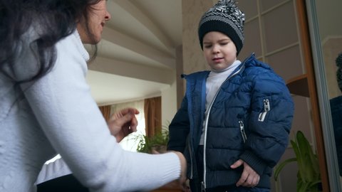 Mother Zipping her Sons Warm Waterproof Children Jacket. Little Child Boy Wearing Winter Attire. 2x Slow motion 60 fps 4K