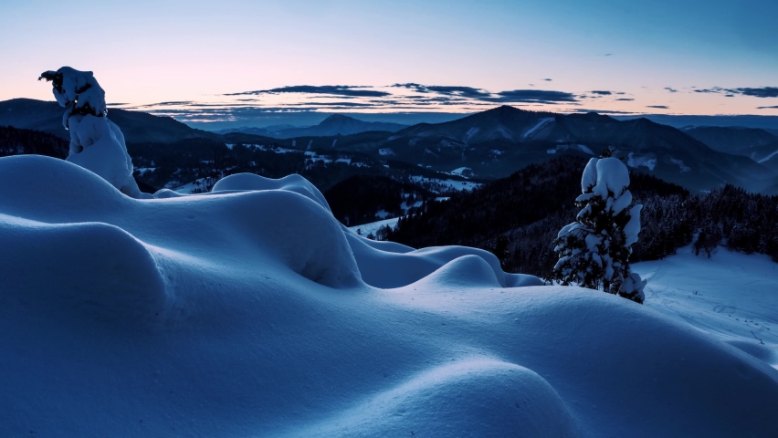 Blue sunrise morning over wild winter mountains nature with frozen snowy forest landscape Time lapse