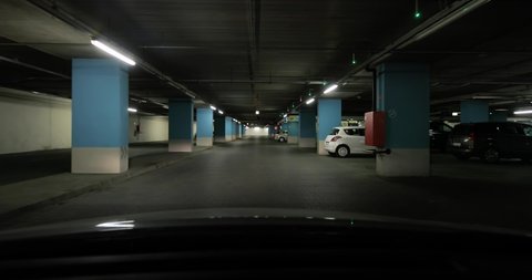 BUDAPEST, HUNGARY - CIRCA 2019: Driving in the parking lot in a basement of a shopping mall, driver's point of view