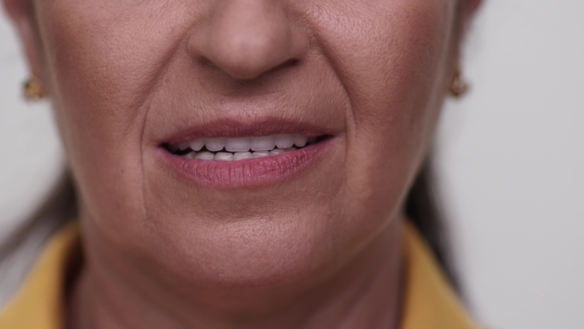 Close-up old woman's sad face. Beautiful teeth and lips of the old woman. | Shutterstock HD Video #1064644228